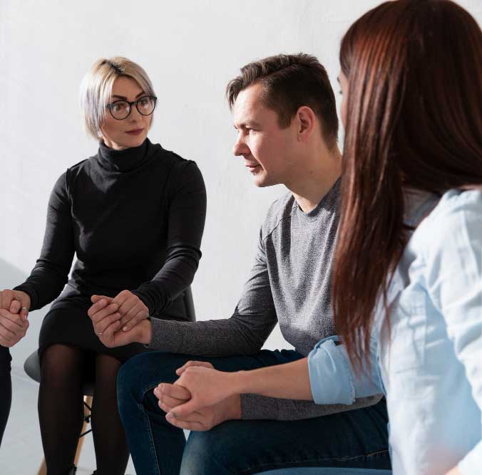 Transition Coach supporting individuals in a small group session, guiding conversation and emotional connection during a personal development discussion